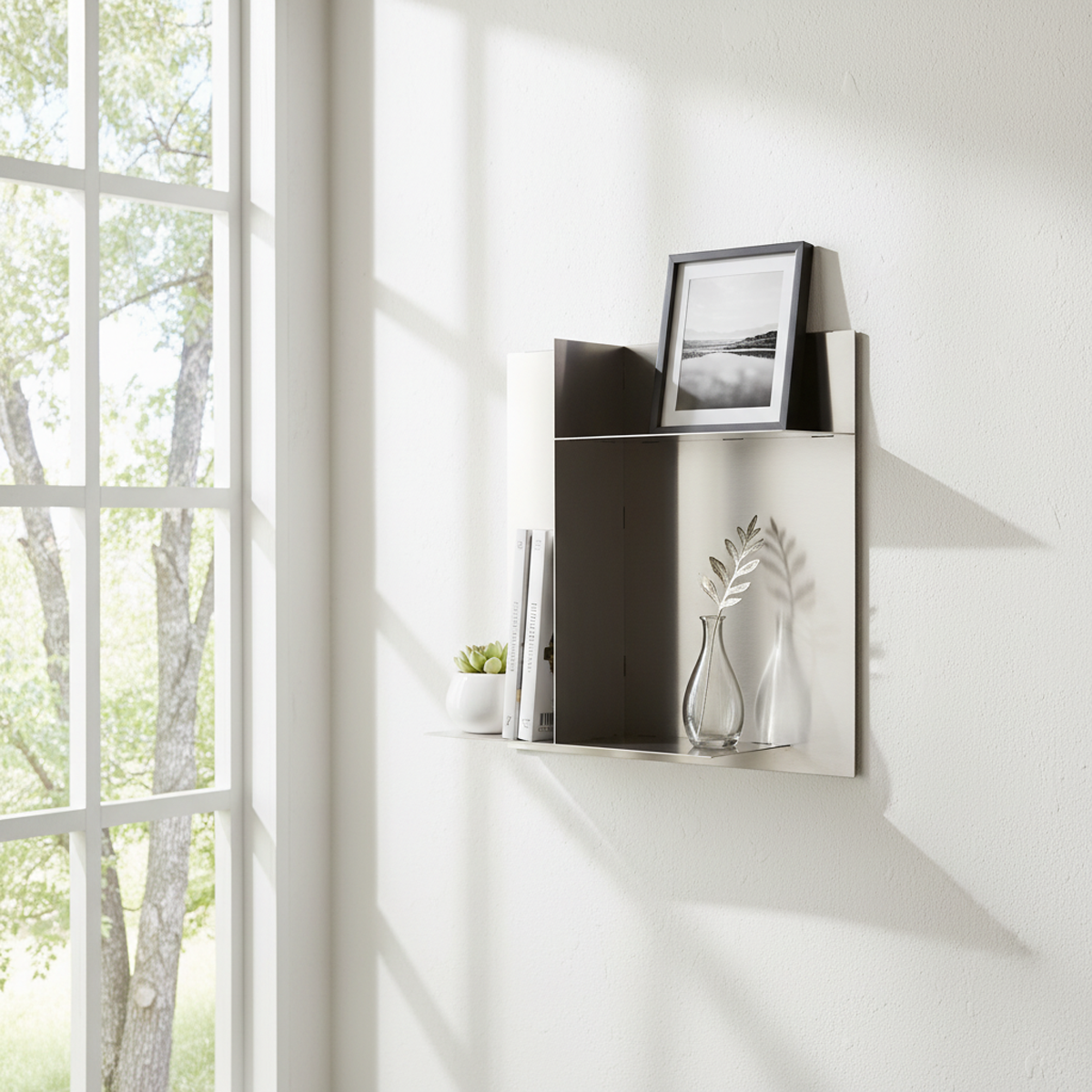 Bespoke stainless steel panel display shelf by Fig & Forge styled with books and minimalist decor, featuring asymmetric storage zones for a modern interior